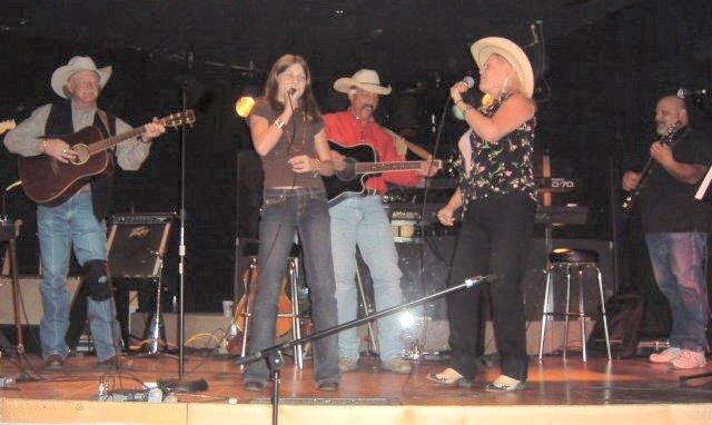 rosegarden.jpg - Sarah Chlarson, 2nd from left, singing with Lynn Anderson on the chorus of Lynn's song, "I Never Promised You A Rose Garden" Picture taken at Doug Kershaw's Bayou Club in Lucern, Colorado.